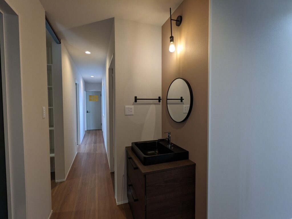 トイレと帰宅時兼用のお洒落な手洗いは、クリナップのエルヴィータ。家具のようなデザインのキャビネットにブラックの洗面台がお洒落です。