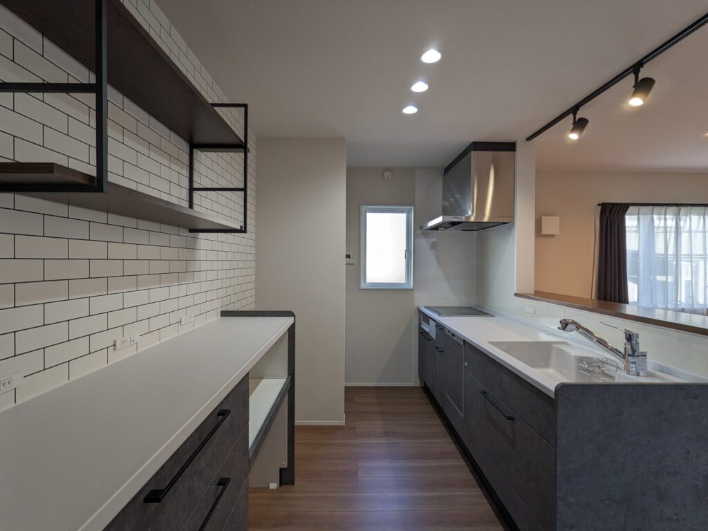 カフェテイストのキッチン。システムキッチン、背面収納共にタカラスタンダードのリフィット。カラーはディープグレー。