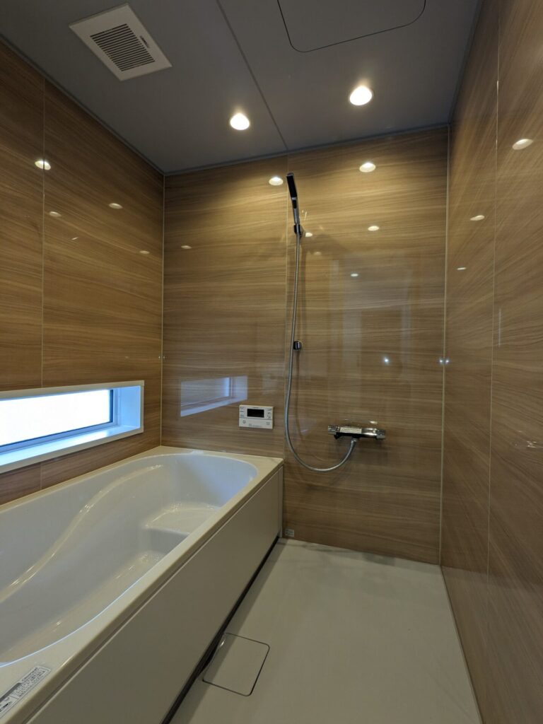 壁全面が木目調の高級感あるバスルーム。